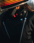 woman with a helmet wearing Black retro style woman's motorcycle jacket with silver zip details