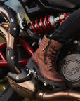 woman's foot on a motorcycle rest wearing brown leather mc boots 
