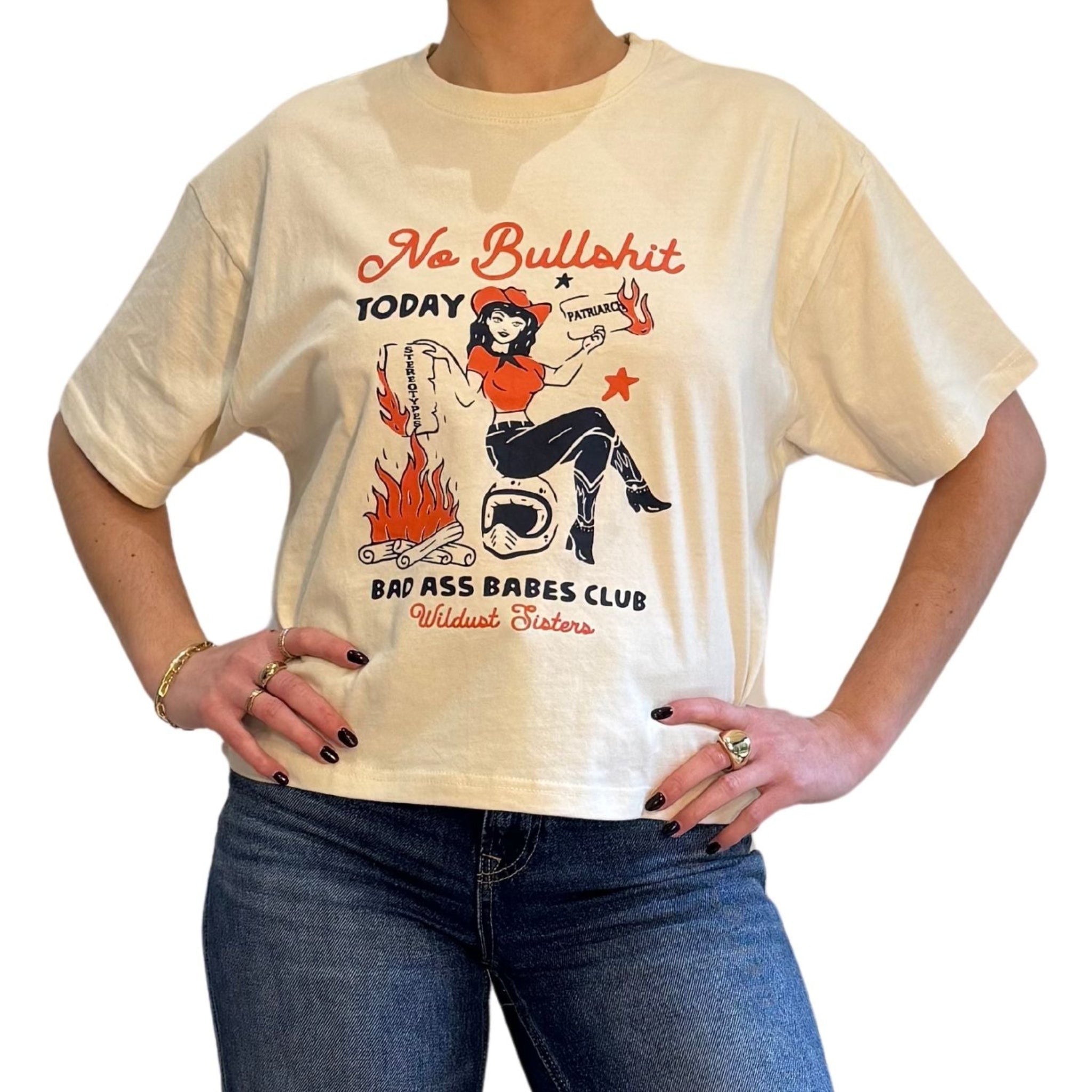 a woman wearing off white/creame colour t-shirt with retro motive that says No bullshit