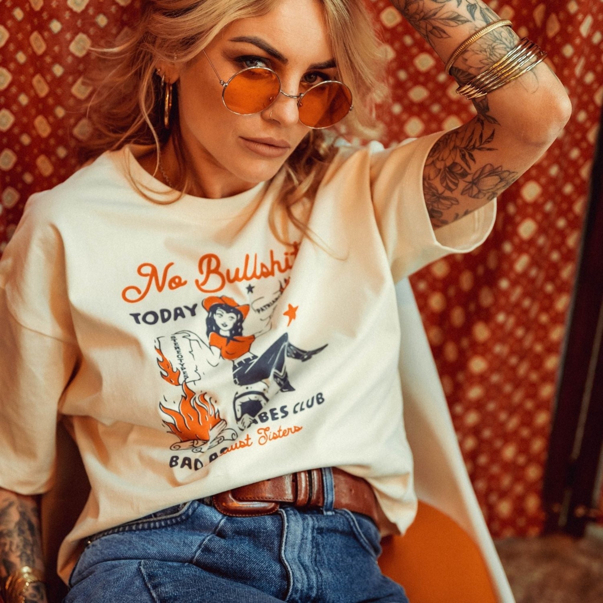 a woman wearing off white/creame colour t-shirt with retro motive that says No bullshit