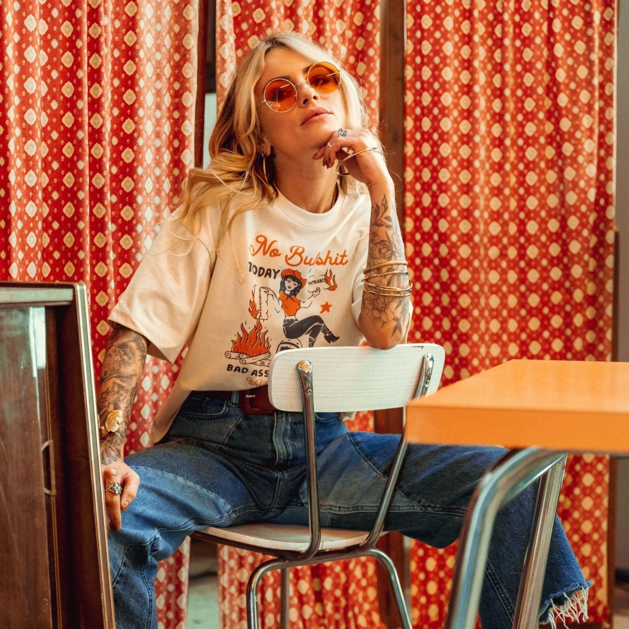 a woman wearing off white/creame colour t-shirt with retro motive that says No bullshit