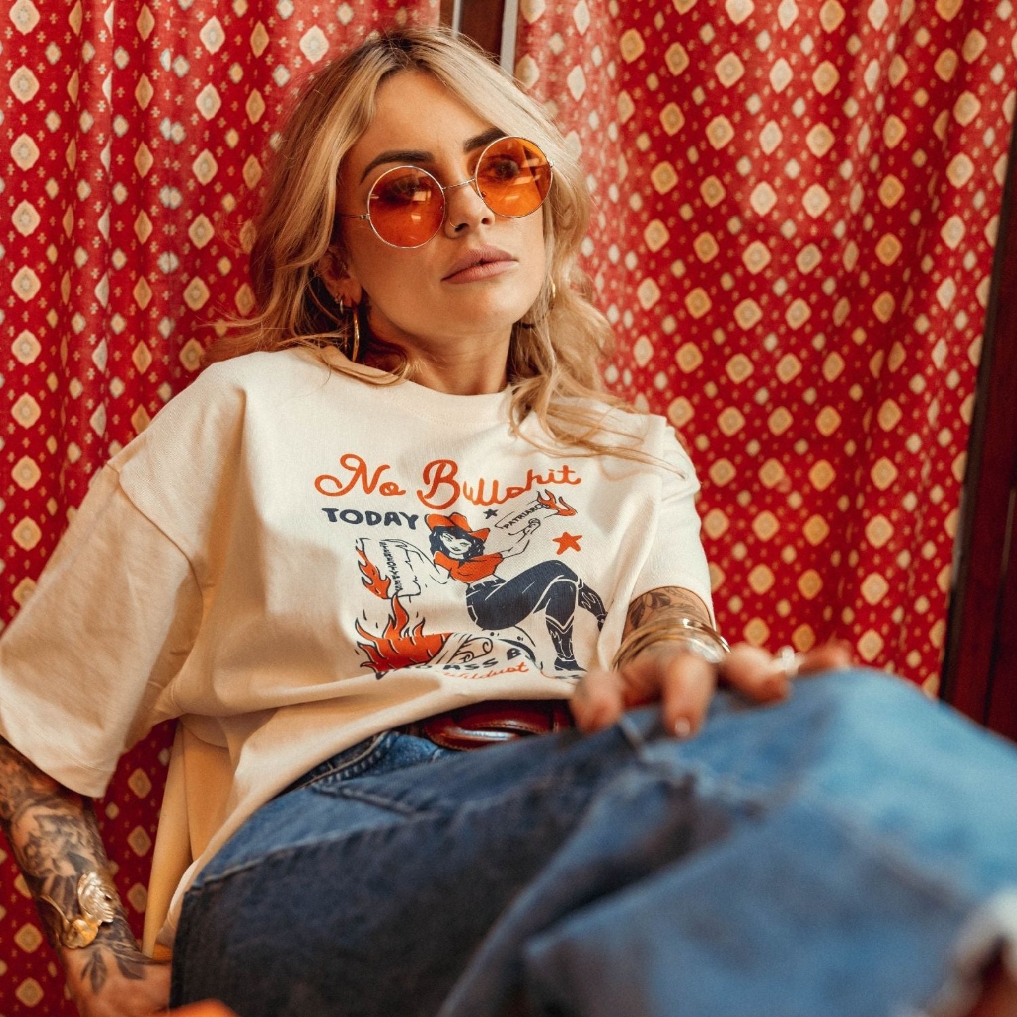 a woman wearing off white/creame colour t-shirt with retro motive that says No bullshit