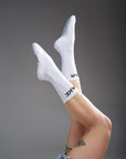 Women's legs wearing white socks  with "break" and "gear"