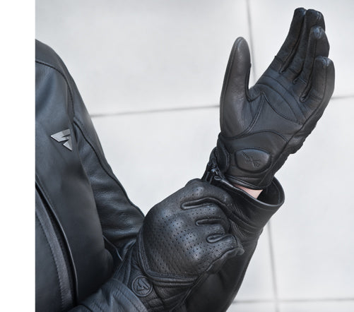 A woman putting on black female motorcycle gloves from Shima 