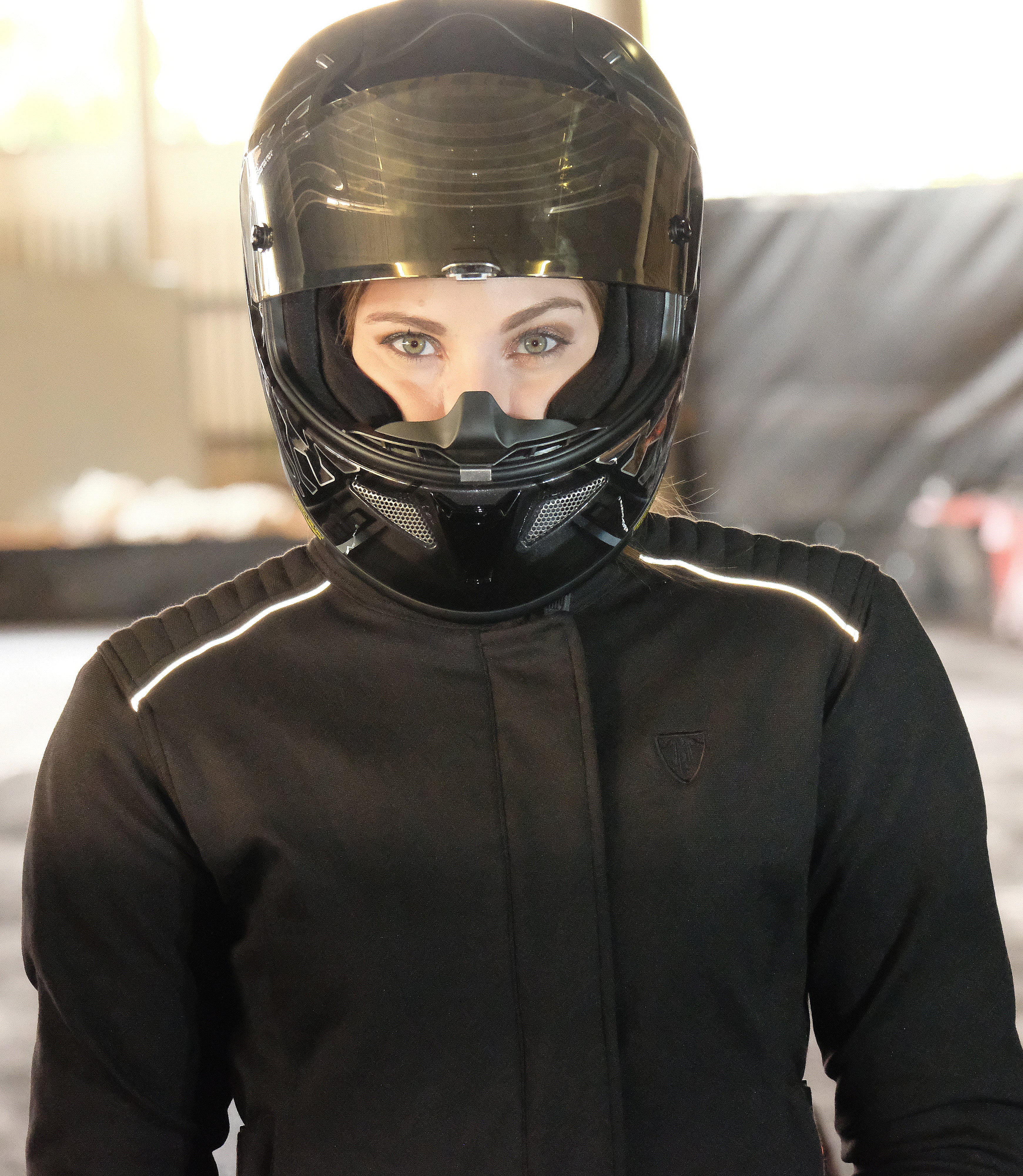 A women with a black helmet and wearing black textile motorcycle jacket from MotoGirl