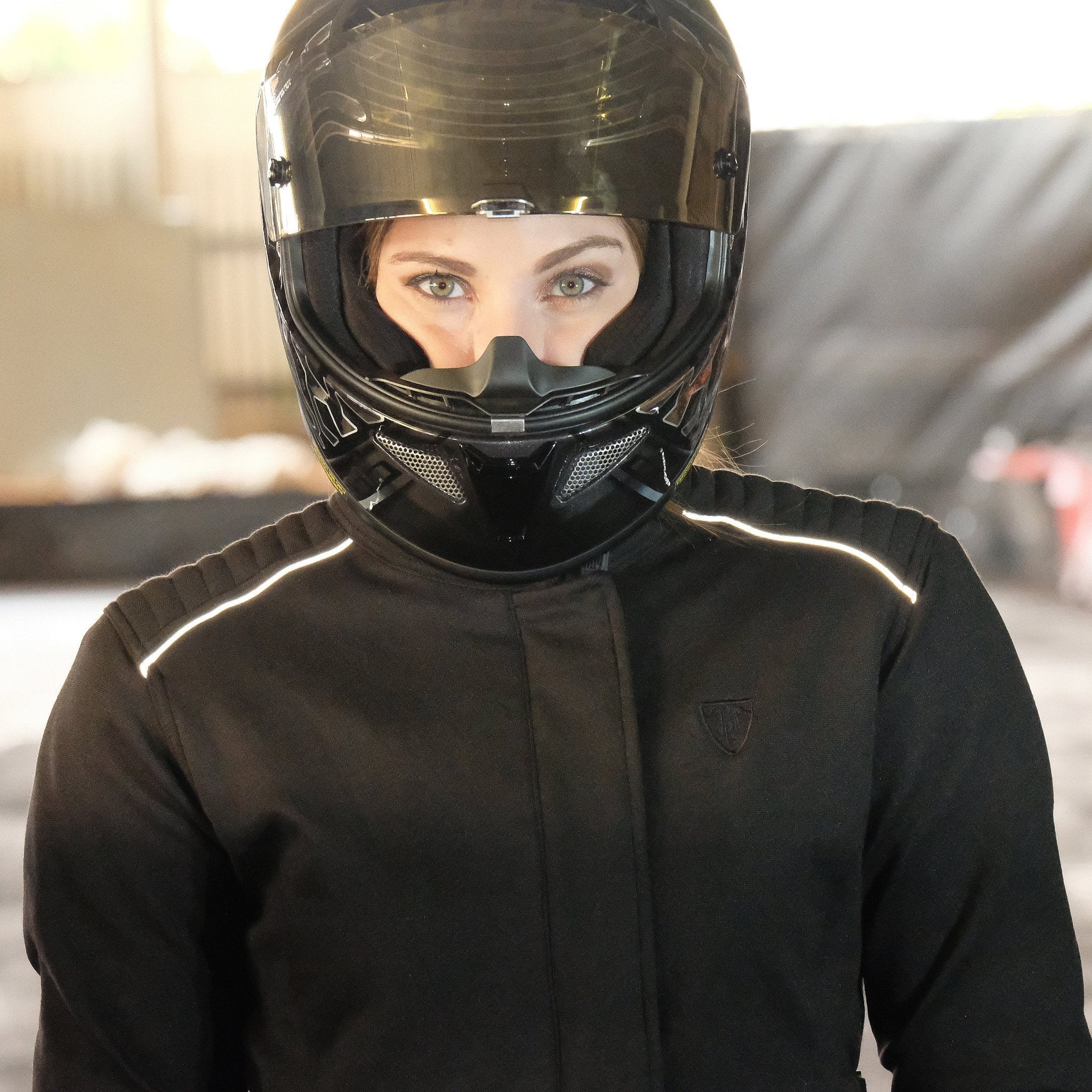 A women with a black helmet and wearing black textile motorcycle jacket from MotoGirl