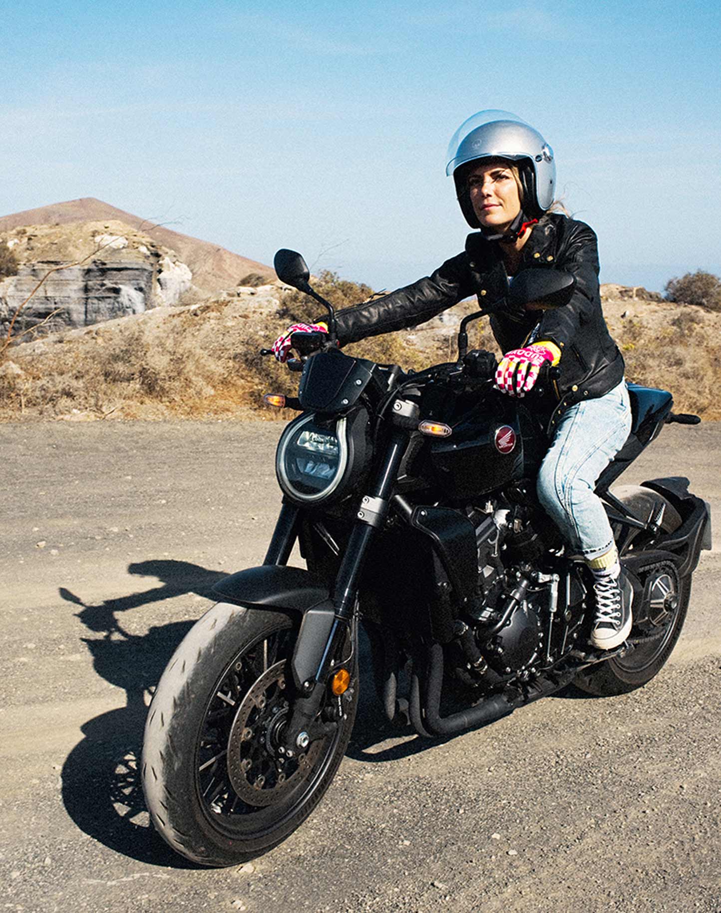 A young woman driving on a motorcycle wearing Classic retro black women&#39;s motorcycle jacket from Eudoxie