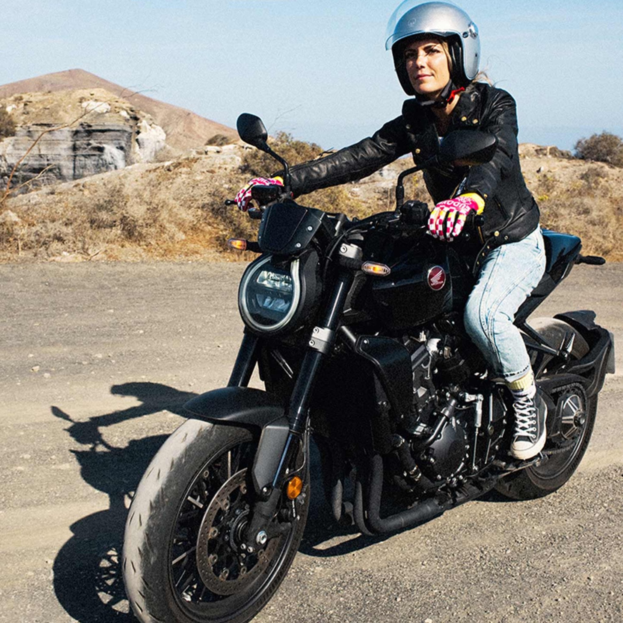 A young woman driving on a motorcycle wearing Classic retro black women&#39;s motorcycle jacket from Eudoxie