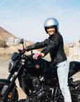 A young woman on a motorcycle wearing Classic retro black women's motorcycle jacket from Eudoxie