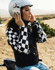 A woman on a motorcycle wearing a Chessboard design leather motorcycle jacket from eudoxie