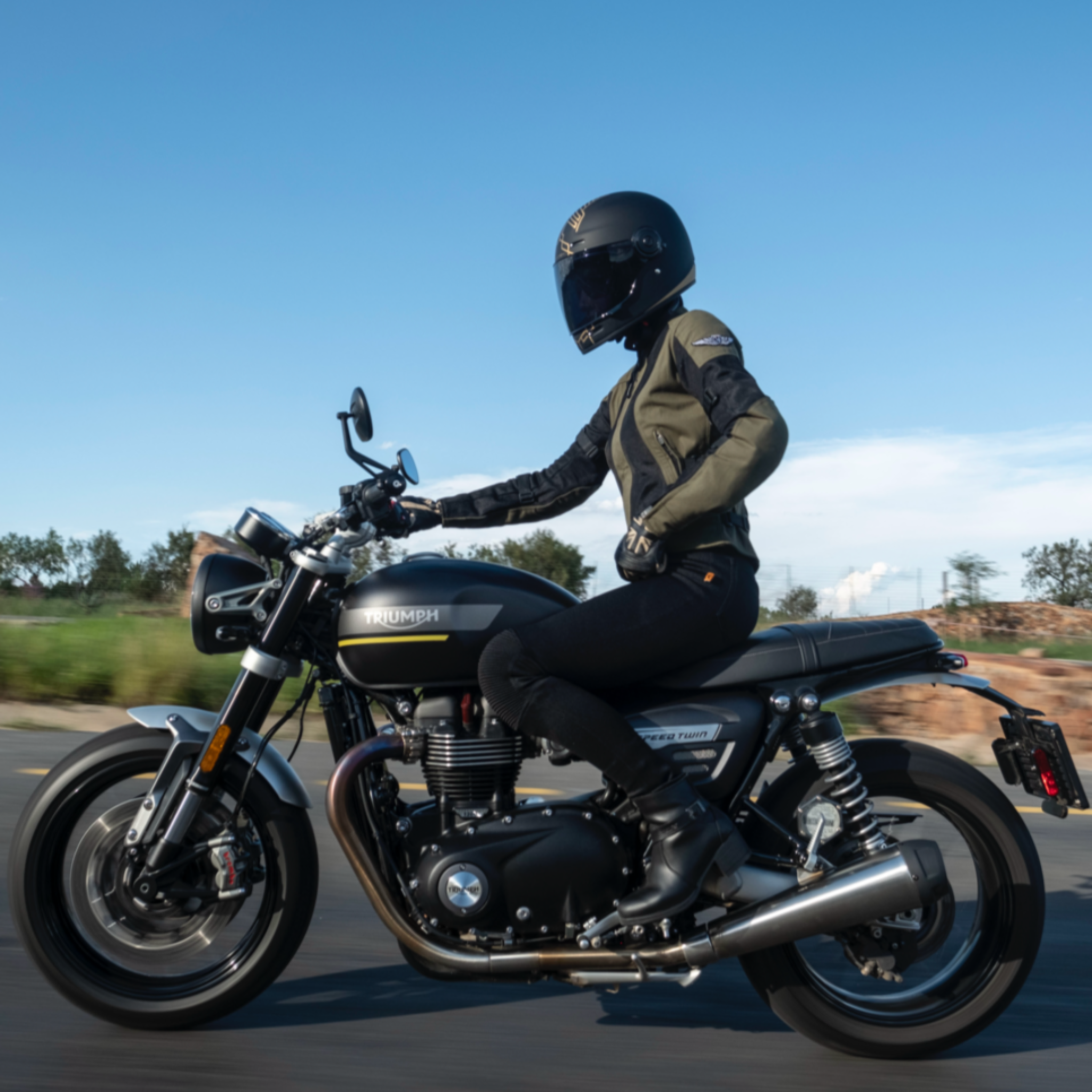 A woman on a motorcycle wearing women's motorcycle summer mesh jacket in black and green from Moto Girl