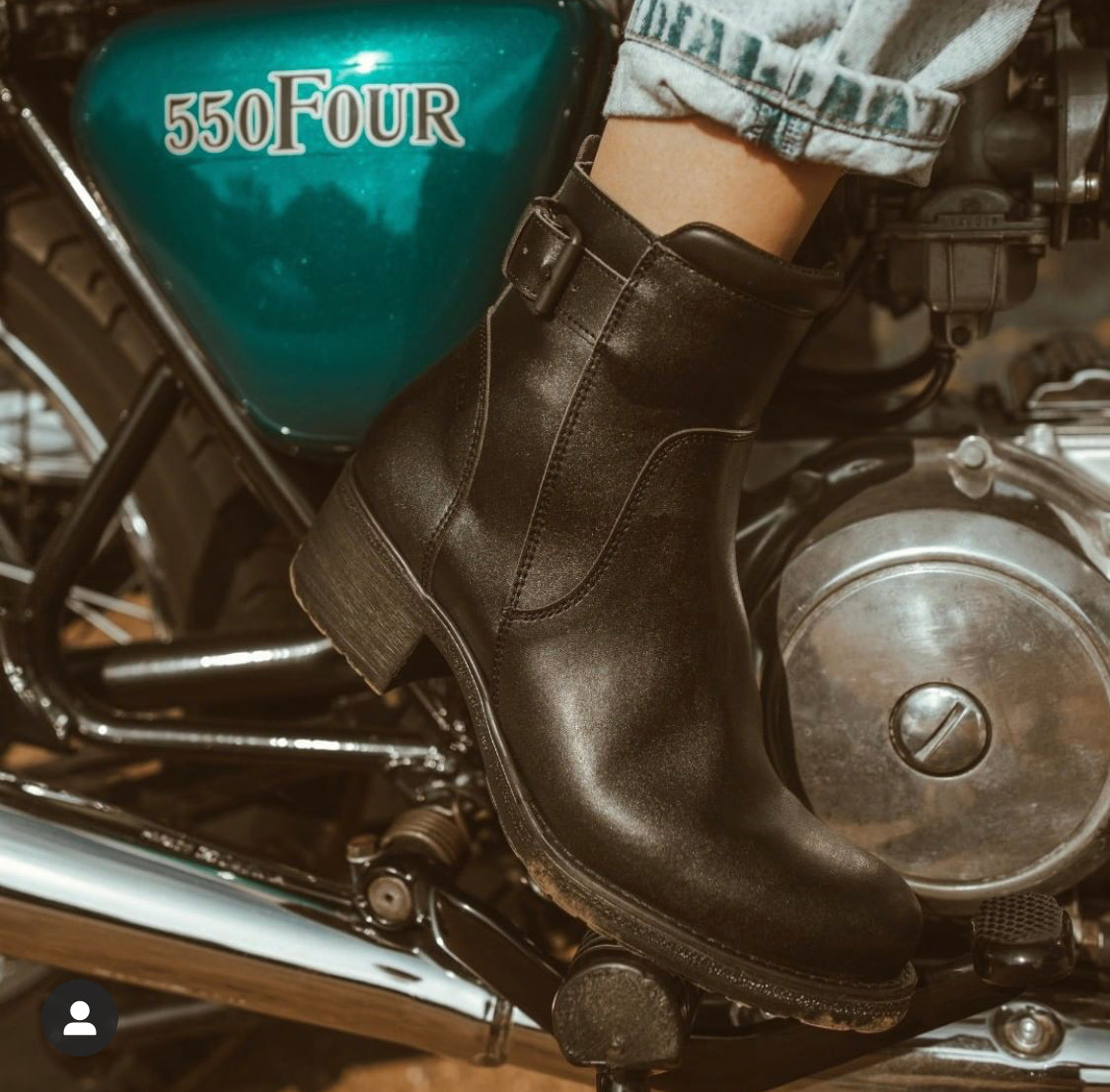 Close up of a woman&#39;s foot on the motorcycle break wearing women&#39;s black leather motorcycle shoes 