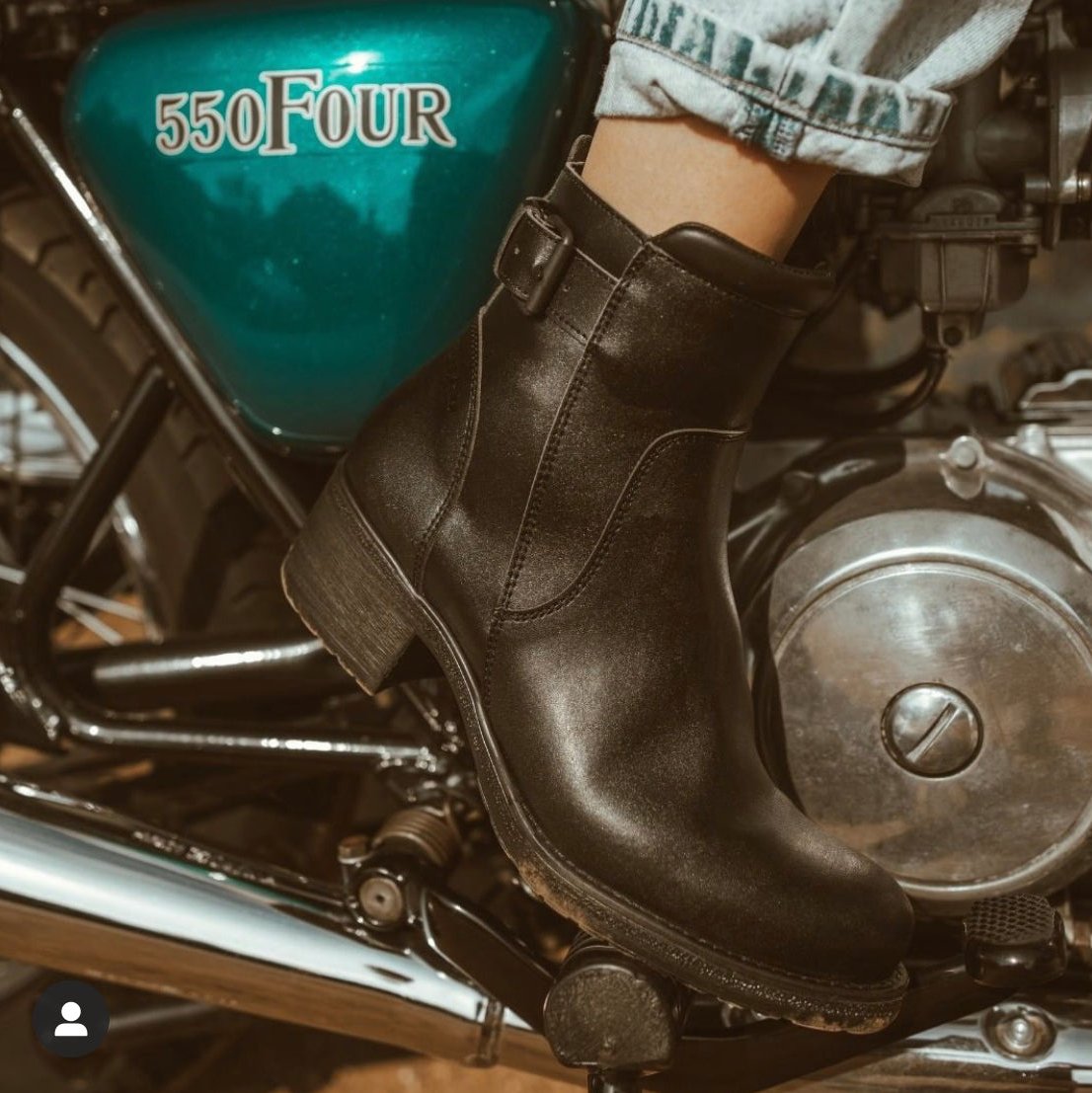 Close up of a woman's foot on the motorcycle break wearing women's black leather motorcycle shoes 