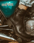 Close up of a woman's foot on the motorcycle break wearing women's black leather motorcycle shoes 