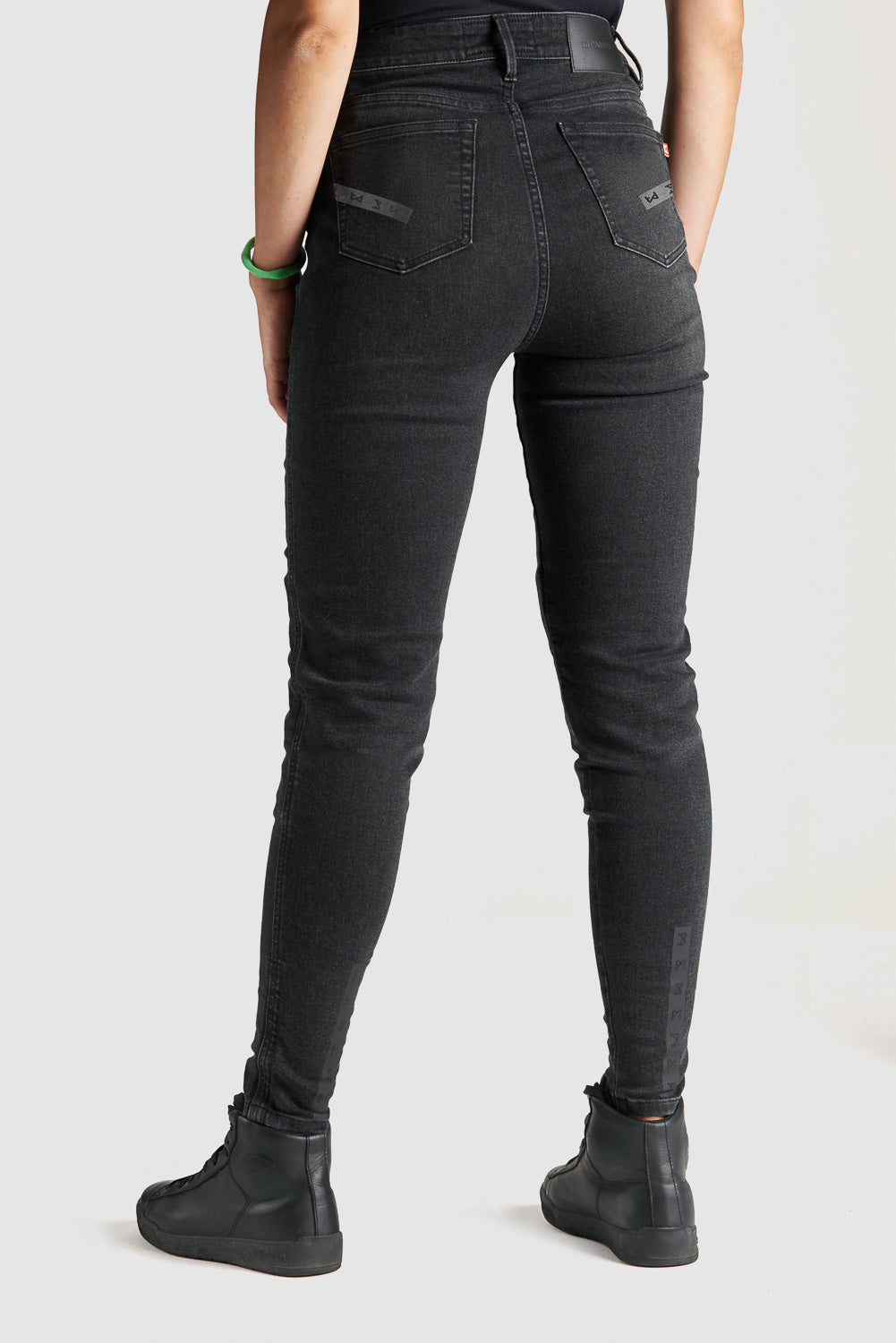 woman's legs  from the back wearing black high waist motorcycle jeans