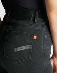A close up of a woman's waist wearing black high waist motorcycle jeans