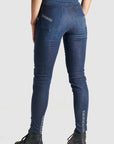 Woman's legs from the back wearing blue motorcycle jeans 