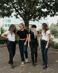 Fire grinende kvinde kvinde iført sorte og blå dame mc jeans