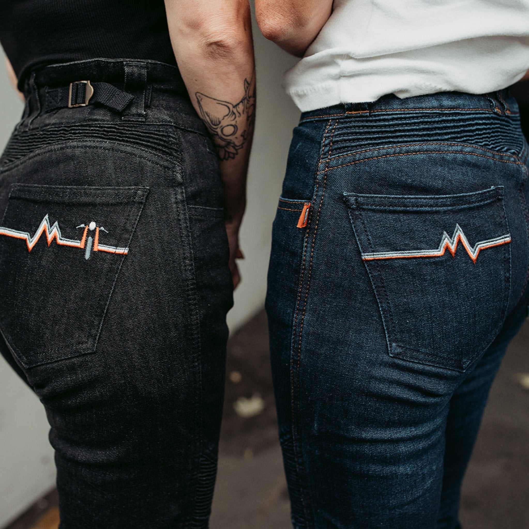 The backs of two women wearing women's motorcycle jeans from Moto Girl with heartbeat detail.