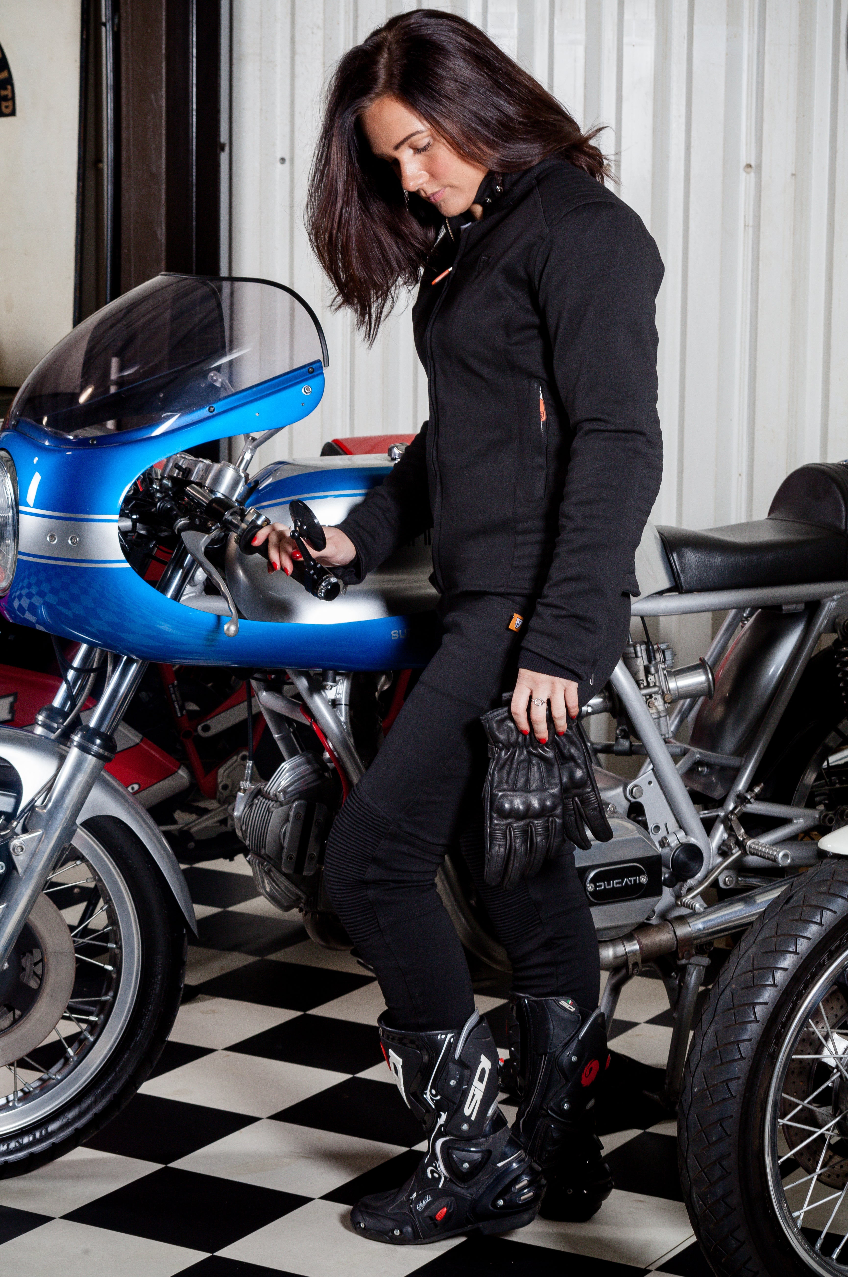 A woman standing by a motorcycle wearing women&#39;s motorcycle clothes from MotoGirl 