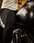 Close up of a woman's, sitting on the motorcycle and wearing black motorcycle leggings, knee