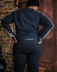 A woman wearing black leggings and sweatshirt