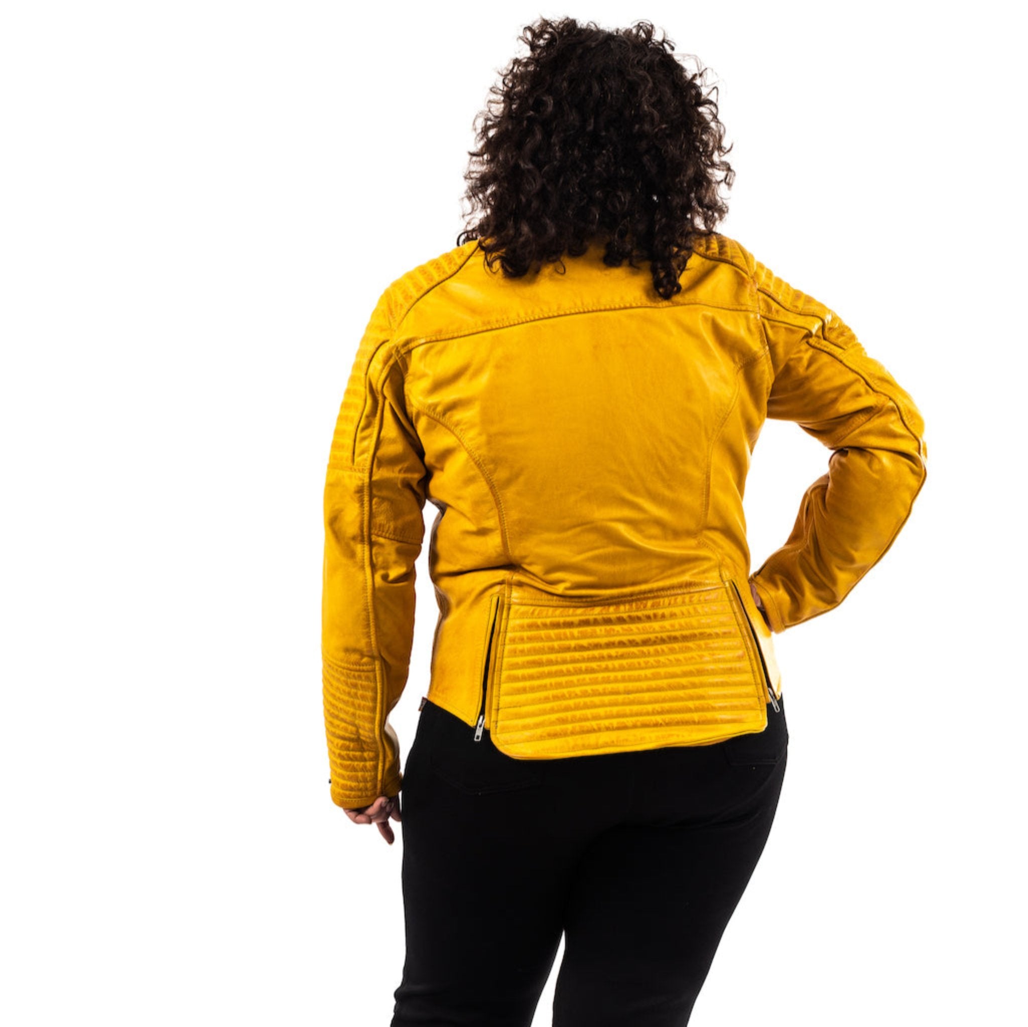 the back of a dark haired woman wearing a yellow motorcycle jacket from moto girl