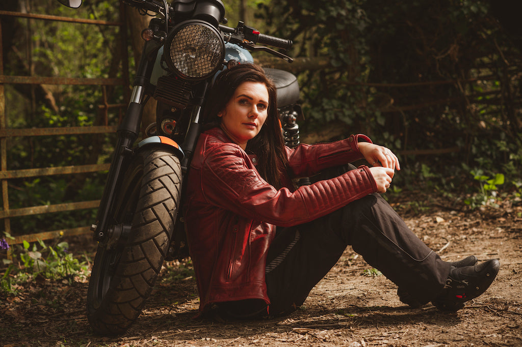 A woman with her motorcycle wearing red Valerie motorcycle leather jacket from Moto Girl