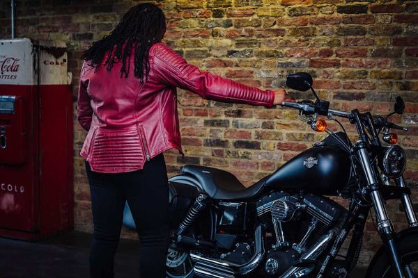 A woman with her motorcycle wearing red Valerie motorcycle leather jacket from MotoGirl