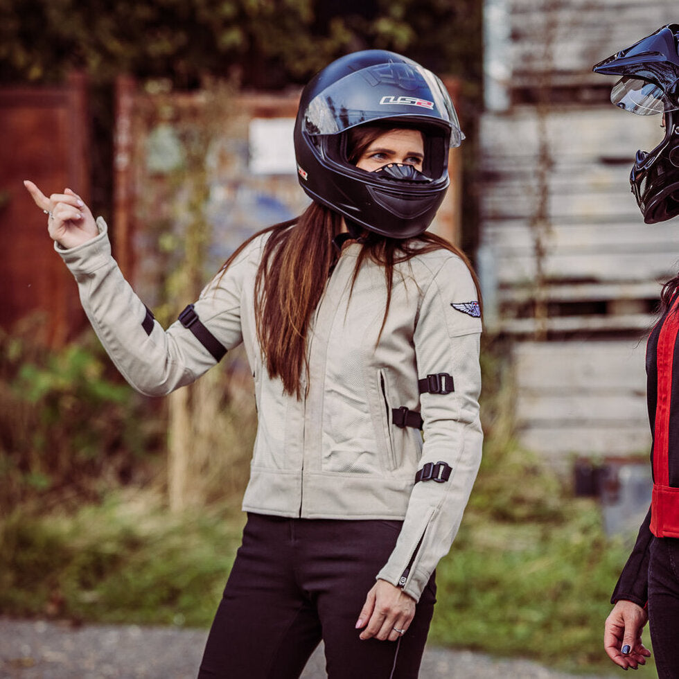 A woman with a helmet wearing  women&#39;s summer mesh motorcycle jacket from Moto Girl and pointing somewhere