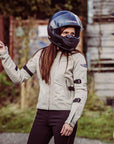 A woman with a helmet wearing  women's summer mesh motorcycle jacket from Moto Girl and pointing somewhere