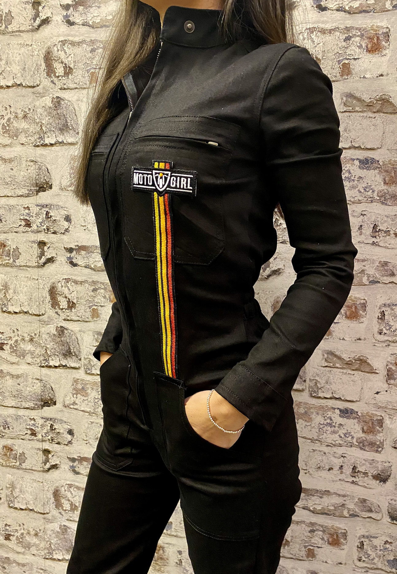 A dark haired woman wearing black garage suit for women from MotoGirl 