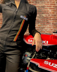 A women leaning on a red Suzuki motorcycle wearing Black garage suit for women from MotoGirl 