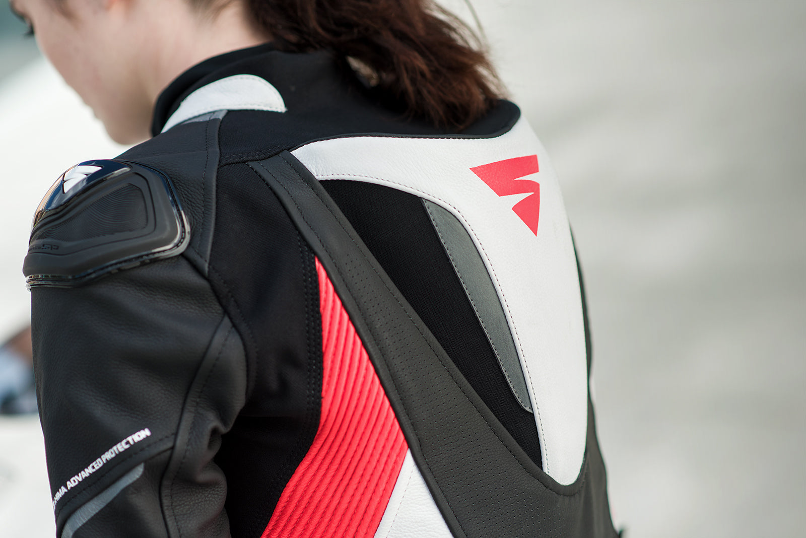 A close up of a woman&#39;s back wearing Women&#39;s racing suit MIURA RS in black, white and fluo from Shima 