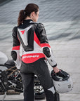 A woman standing near her motorcycle wearing Women's racing suit MIURA RS in black, white and fluo from Shima 
