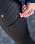woman's hand zipping a pocket on lady motorcycle trousers