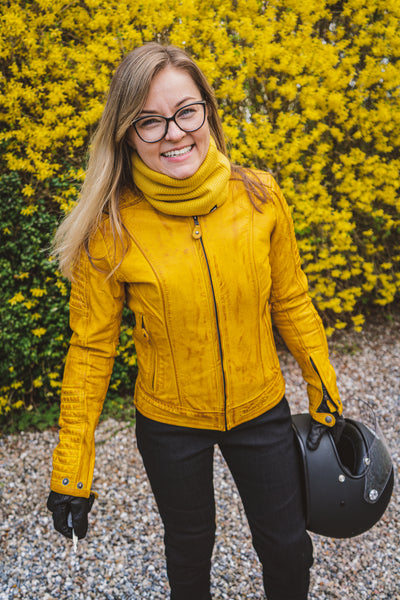 A smiling woman wearing yellow women's motorcycle leather jacket 