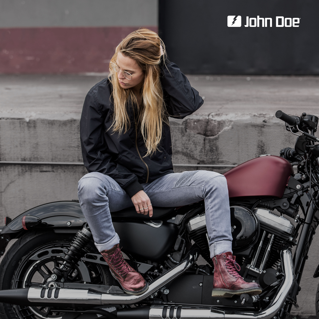 A young woman on a motorcycle wearing red women&#39;s motorcycle boots