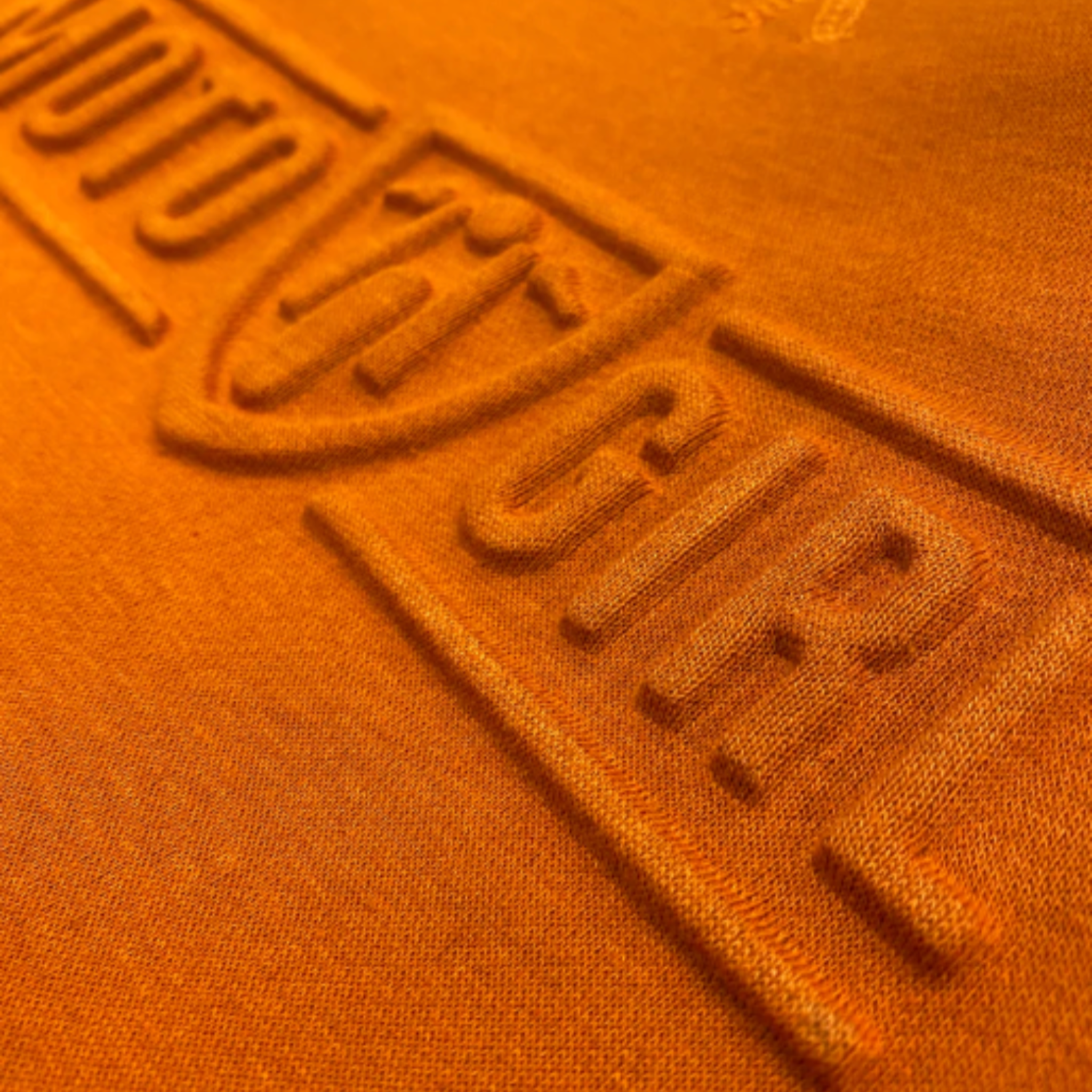 A close up of the 3d logo on a women's motorcycle sweatshirt from Moto Girl in the color burnt orange