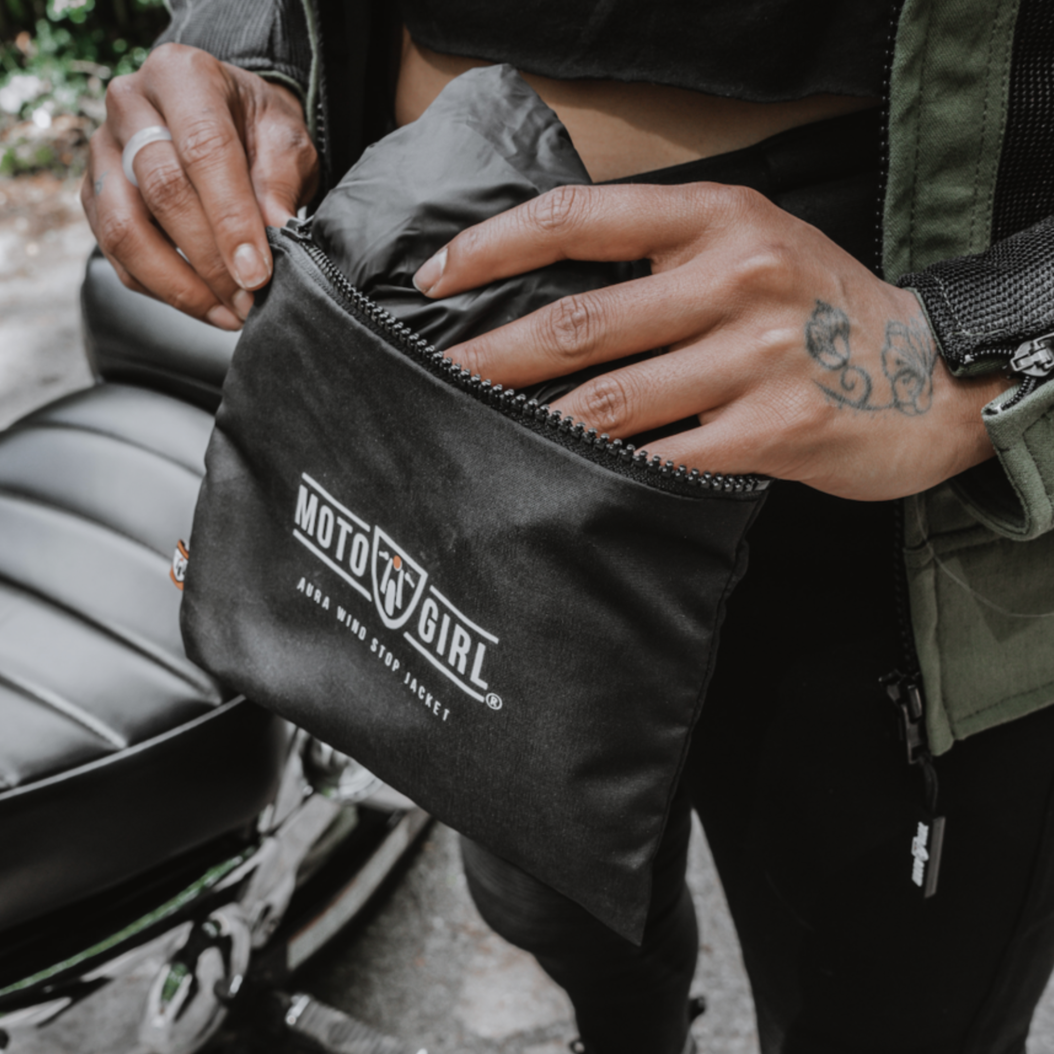 Women's hands taking out a jacket from the bag with Moto Girl logo