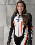 A smiling woman wearing Women's racing suit MIURA RS in black, white and fluo from Shima 
