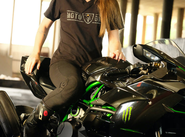 A woman on a motorcycle wearing motorcycle leggings and MotoGirl Tshirt