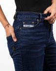 A close up of the label on Woman's legs wearing dark blue high waisted women's motorcycle jeans from JohnDoe
