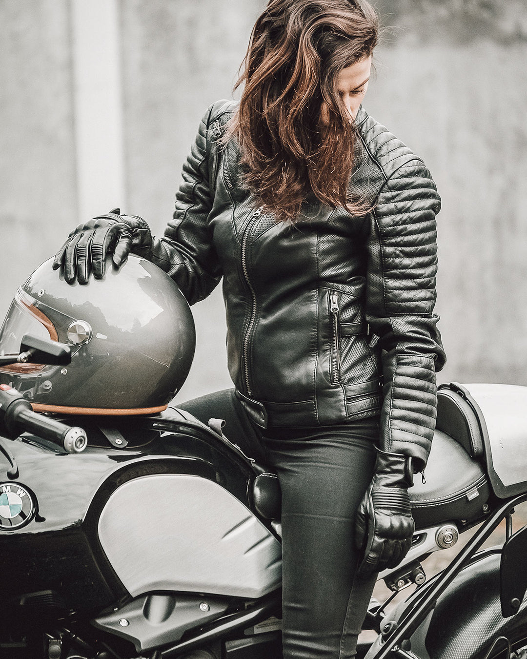 A woman on a motorcycle wearing Women&#39;s black leather motorcycle jacket modern classic style from Black arrow label