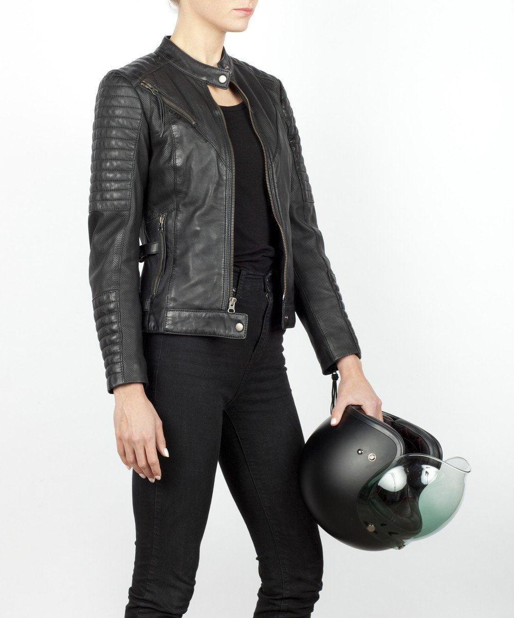 A woman holding a helmet and wearing Women&#39;s black leather motorcycle jacket modern classic style from Black arrow label