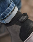 A close up of the motorcycle shoe and motorcycle jeans reflective stripe