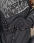a hand unzipping the ventilation panel on the grey women's motorcycle jacket from SHIMA