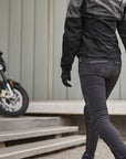 a woman walkig towards her motorcycle wearing grey women's motorcycle jacket from SHIMA