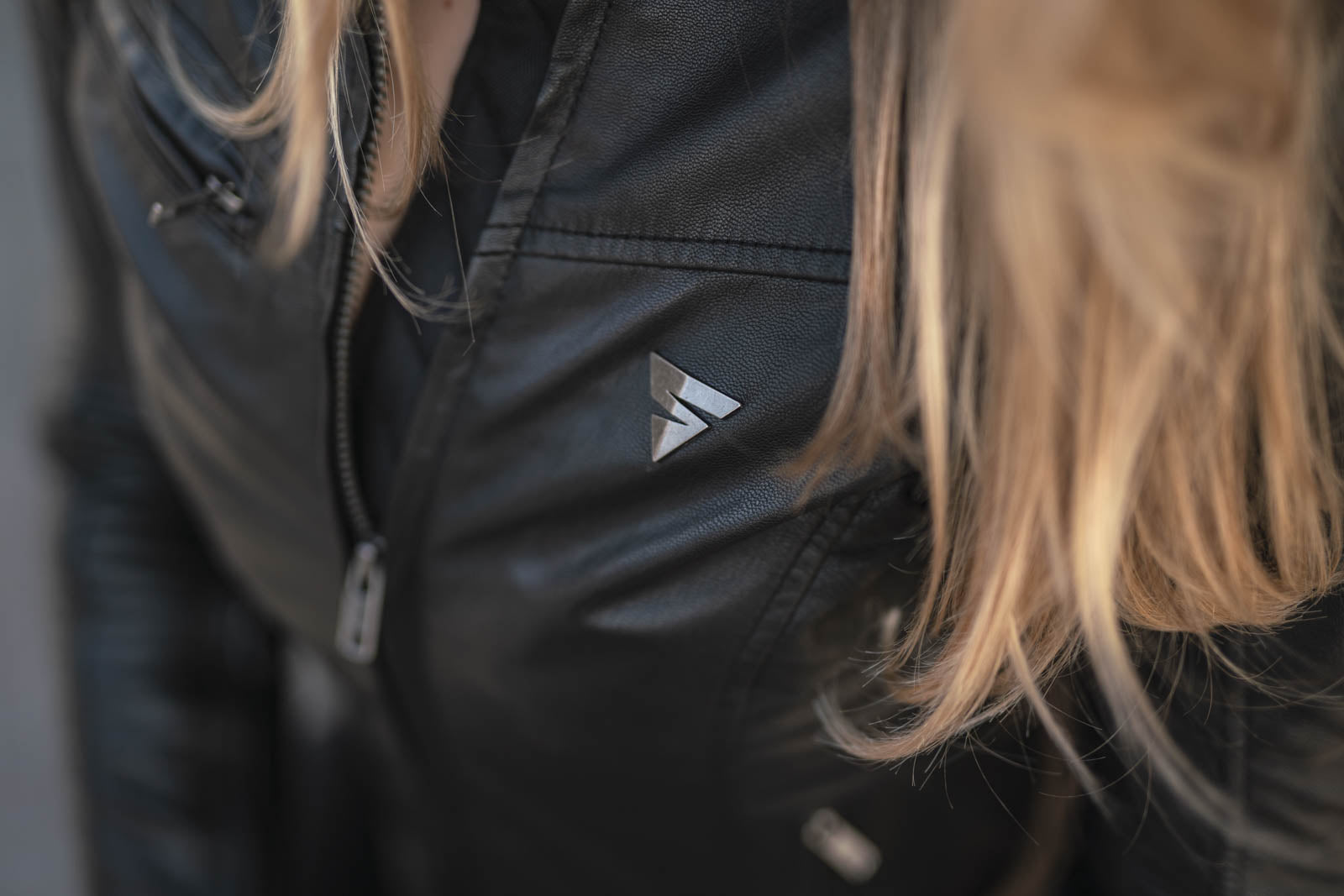 A close up of woman&#39;s chest wearing black motorcycle jacket