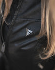 A close up of woman's chest wearing black motorcycle jacket